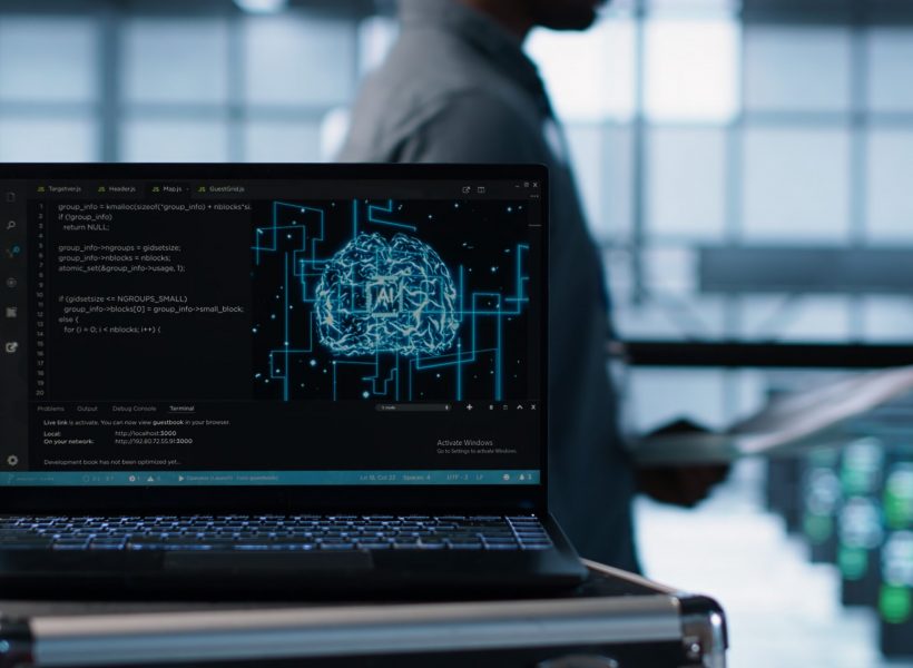 Artificial intelligence technology coding on laptop in data center with programmers in background employing machine learning models. Notebook used by AI IT experts, camera A close up